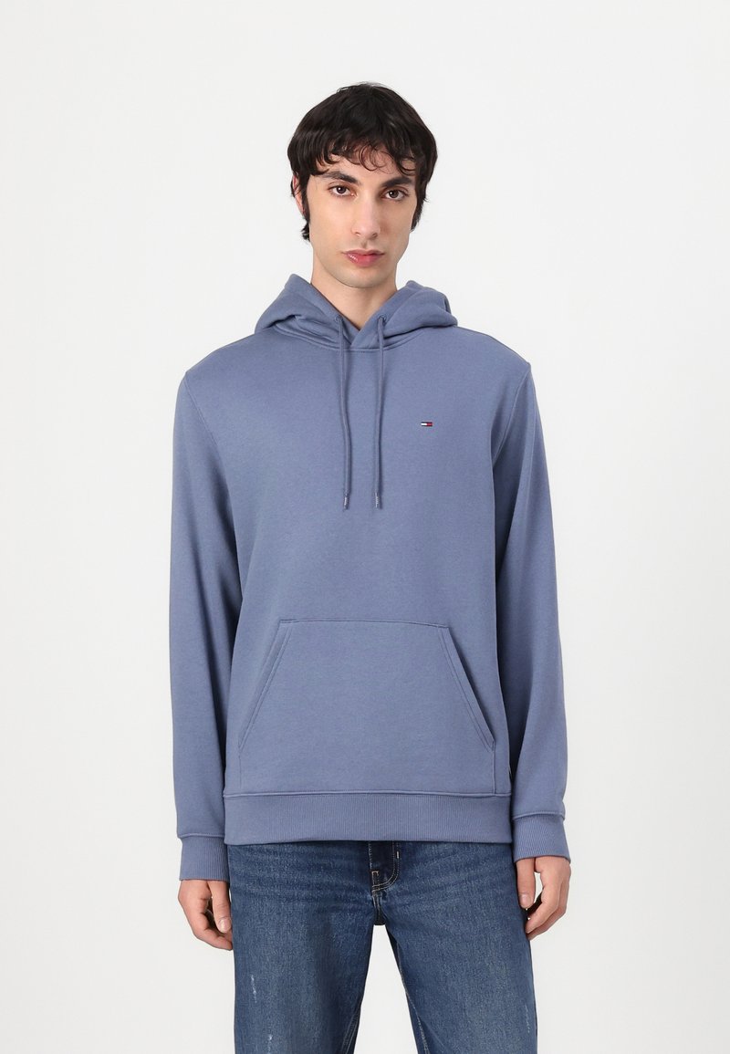 Felpa blu realizzata in tessuto morbido con tasca frontale e cappuccio regolabile. Presenta un piccolo logo sul petto. Vestibilità casual con polsini a coste.