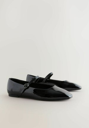 Zwarte gepolijste leren balletschoenen met puntige neuzen, een platte zool en een smalle band over de wreef met een ronde gesp als detail.