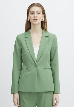 Blazer ajusté vert avec une fermeture à un bouton, des revers crantés et deux poches latérales. Fabriqué en tissu lisse avec une coupe structurée.