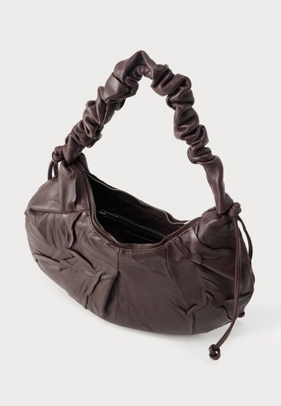 Rjava usnjena torbica z nabranim, mehkobnim teksturo in stisnjenim ročajem. Ima zadrgo na vrhu in prostorno notranjost.