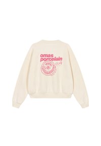 Sweat-shirt oversize couleur crème avec poignets et ourlet côtelés, présentant des motifs roses d'une tasse et un design floral au dos.