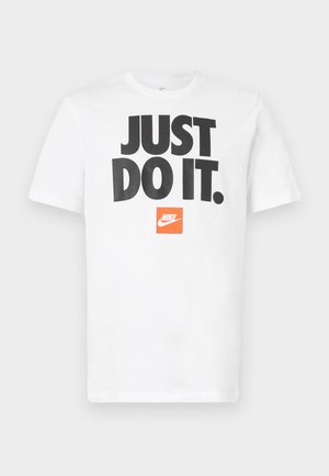 Camiseta blanca de algodón con mangas cortas, que presenta un atrevido texto negro "JUST DO IT." y un logo de Nike naranja encima.