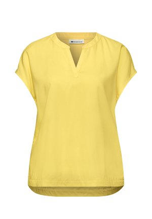 Blouse jaune à manches courtes avec une fente en V et une coupe ample, conçue pour une tenue décontractée.