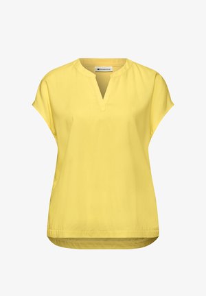 Blouse jaune à manches courtes avec une fente en V et une coupe ample, conçue pour une tenue décontractée.