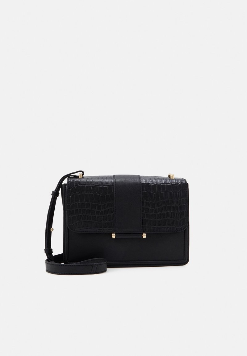 Sort rektangulær crossbody taske med struktureret låg, central rem og justerbar skulderrem på hvid baggrund.