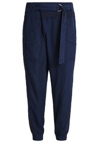 Pantalon bleu marine fuselé avec des poignets élastiques, de grandes poches avant et une ceinture en tissu avec une boucle en D métallique à la taille.