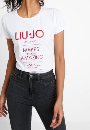 Biała bawełniana koszulka z czerwonym nadrukiem: "LIU•JO MILANO sprawia, że każdy dzień jest niesamowity z miłością od 1995 roku." Klasyczny, okrągły dekolt, krótki rękaw.