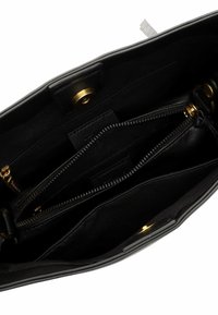 Binnenkant van een zwarte leren tas met meerdere vakken, voorzien van een gouden ritssluiting en drukknoopsluitingen.