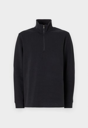 Juodas ilgomis rankovėmis puloveris su stovinčiu apykakle ir ketvirčio ilgio užtrauktuku priekyje, ant baltos fono.