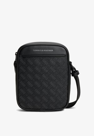 Sac bandoulière noir Tommy Hilfiger avec panneau avant texturé et sangle d'épaule réglable sur fond blanc.