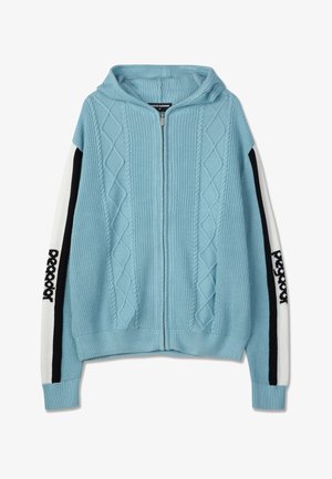 Lyseblå hettegenser med glidelås og diamantstrikkemønster. Har hvite ermer med svarte detaljer og logo. Teksturert strikket stoff.