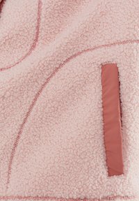 Roze fleece stof met een gestructureerd, krullend oppervlak en een gladde, rechthoekige zakopening aan de rechterkant.