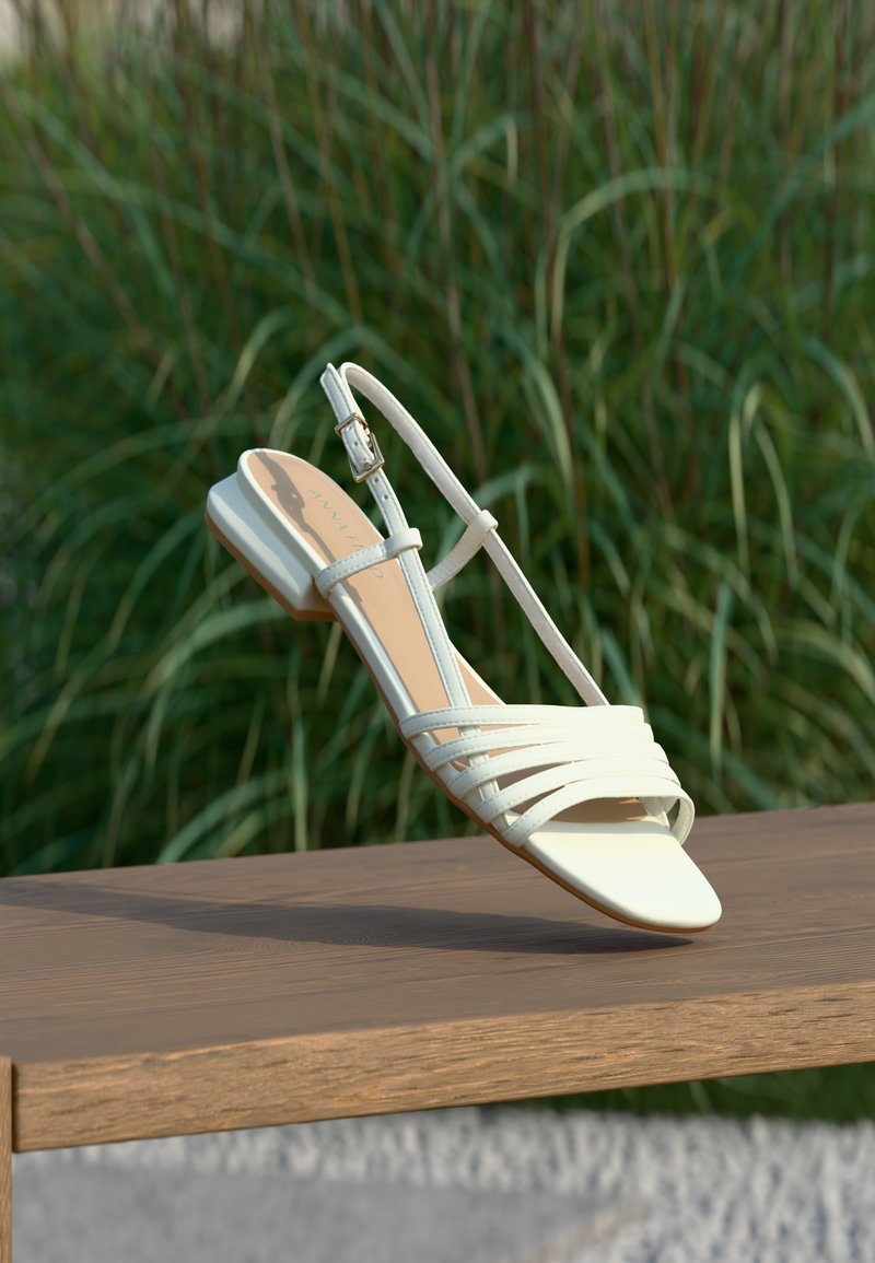 Sandalo beige chiaro con più cinturini incrociati, cinturino sottile alla caviglia e tacco basso a blocco. Materiale in pelle liscia e design con punta aperta.