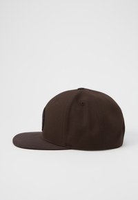 Cappello marrone con visiera piatta e corona strutturata, caratterizzato da un colore uniforme e tessuto testurizzato. La parte posteriore è in rete per una maggiore traspirabilità.