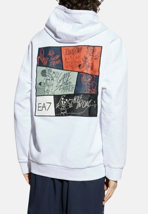 Personne portant un sweat à capuche blanc avec des panneaux de bande dessinée sportifs colorés dans le dos, présentant des mascottes de basket-ball, de football, de tennis et de golf.