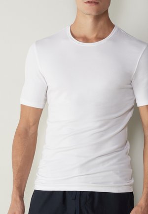 Weißes kurzärmeliges T-Shirt aus leichtem Baumwollstoff. Mit einem runden Ausschnitt und einer glatten Textur, enganliegendem Schnitt und minimalen Nähten.