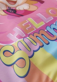 Tessuto colorato con un personaggio dei cartoni animati e la scritta "CIAO ESTATE" in lettere grasse e arrotondate, su uno sfondo a strisce rosa e pastello.