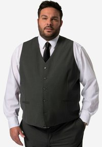 Dunkelgraue Weste mit sechs Knöpfen, zwei vorderen Taschen, getragen über einem weißen Hemd und einer schwarzen Krawatte. Glattes Material mit taillierter Passform.