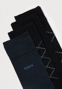 Σύνολο τεσσάρων κάλτσων: δύο μαύρες, μία σκούρα μπλε με το λογότυπο "BOSS", μία μαύρη με γεωμετρικό σχέδιο. Μείγμα βαμβακιού, ραβδωτή υφή.