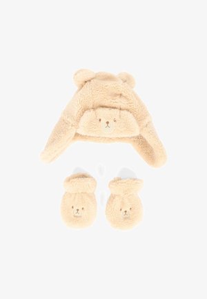 Cappello beige, soffice a tema orso con orecchie e dettagli del viso; abbinato a guanti coordinati con facce di orso. Tessuto morbido e testurizzato, design accogliente.