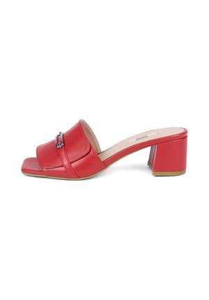 Rode leren open-toe mule met blokhak, decoratieve metalen gesp en vierkante neus op een witte achtergrond.