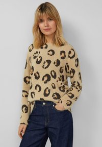 Beige trui met luipaardprint in zwart en bruin, gemaakt van zacht, getextureerd materiaal. Voorzien van lange mouwen en een losse pasvorm.
