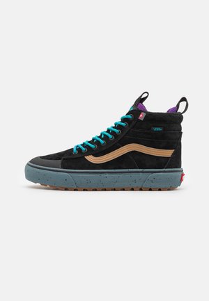 Black suede high-top sneaker with turquoise laces, tan accents, a gray speckled sole, and purple lining. Side branding visible.