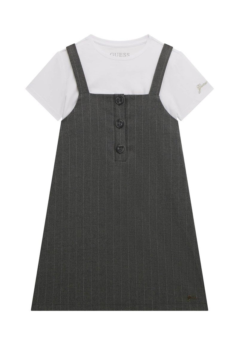 Vestito grigio a righe con bretelle, caratterizzato da tre bottoni neri sul davanti e una t-shirt bianca sotto. Dettaglio del logo discreto sulla manica.