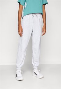 Heledad hallhalli dressipüksid pehmest kangast elastse vöökoha ja varrukatega. Ühildatud türkiissinise lühikese varrukaga särgiga ja valgete tossudega.