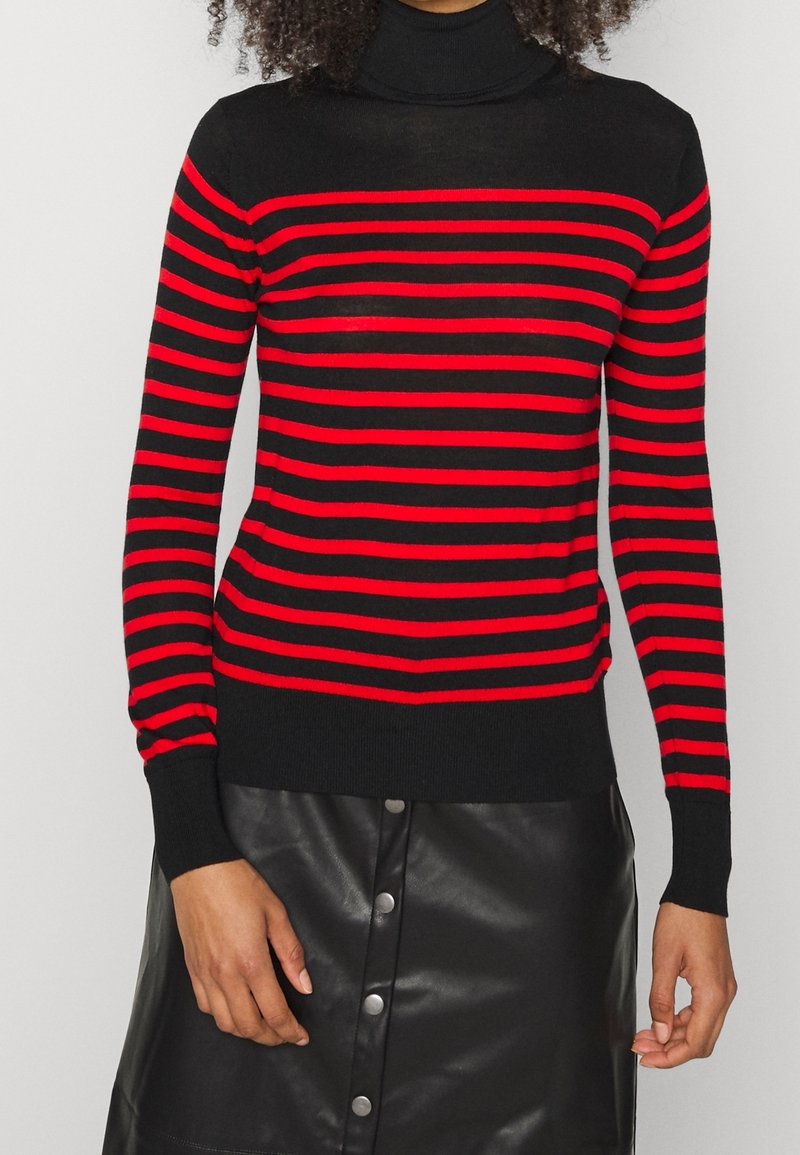 Maglione a collo alto nero con audaci strisce orizzontali rosse. Texture morbida. Presenta maniche lunghe e polsini e orlo a coste.