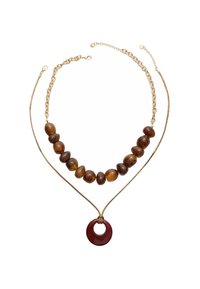 Collana a due strati con perline marroni, una catena dorata e un pendente circolare rosso. Perline testurizzate e accenti lucidi arricchiscono il design.