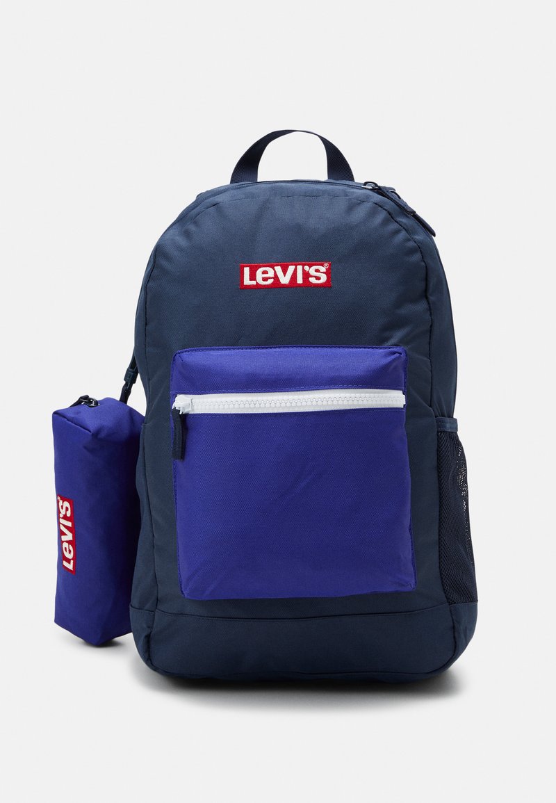 Sac à dos bleu marine avec un logo rouge de Levi's, doté d'une grande pochette avant violette avec une fermeture éclair blanche, fabriqué en tissu durable, comprend une poche latérale en maille.