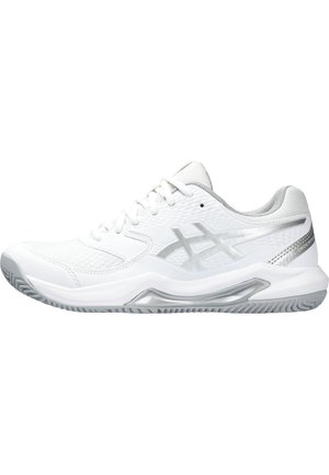 Zapatilla deportiva blanca con suela gris, logo plateado en el lateral, parte superior de malla y cordones, mostrada de perfil mirando hacia la izquierda.