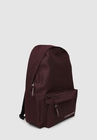 Burgundowa plecak z tkaniny z zaokrąglonym dnem, regulowanymi paskami, przednią kieszenią na zamek oraz markowymi uchwytami suwaka. Gładka tekstura, minimalistyczny design.