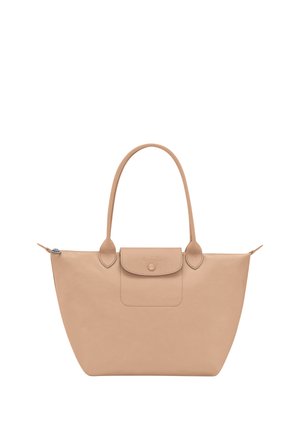 Beige large tote bag with rounded handles, a front flap pocket with button closure, and a zipper on top.