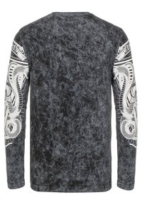 Schwarzes Langarm-T-Shirt mit strukturierter Oberfläche. Mit weißen grafischen Designs von Schlangen auf beiden Ärmeln und rundem Halsausschnitt.