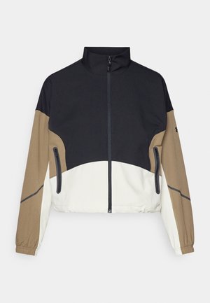 Farbblockierte Jacke mit schwarzem Oberteil, braunen Ärmeln und einem weißen unteren Abschnitt. Sie hat einen hohen Kragen, einen Reißverschluss auf der Vorderseite und zwei Seitentaschen.