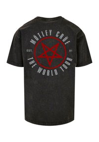 Must t-särk mustast puuvillast, millel on seljal suur punane pentagrammi graafika ja tekst "MÖTLEY CRÜE THE WORLD TOUR EST. 81". Tavaline ümar kaeluse disain.