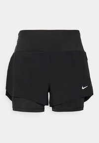 Pantalones cortos deportivos negros con un diseño de capas, con una cintura ancha y un pequeño logo blanco de Nike en la parte inferior derecha.