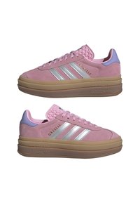 Pink Adidas Gazelle-sneakers med sølvstriber, tykke beige platformsåler og lavendel hælaccents vist fra siden.