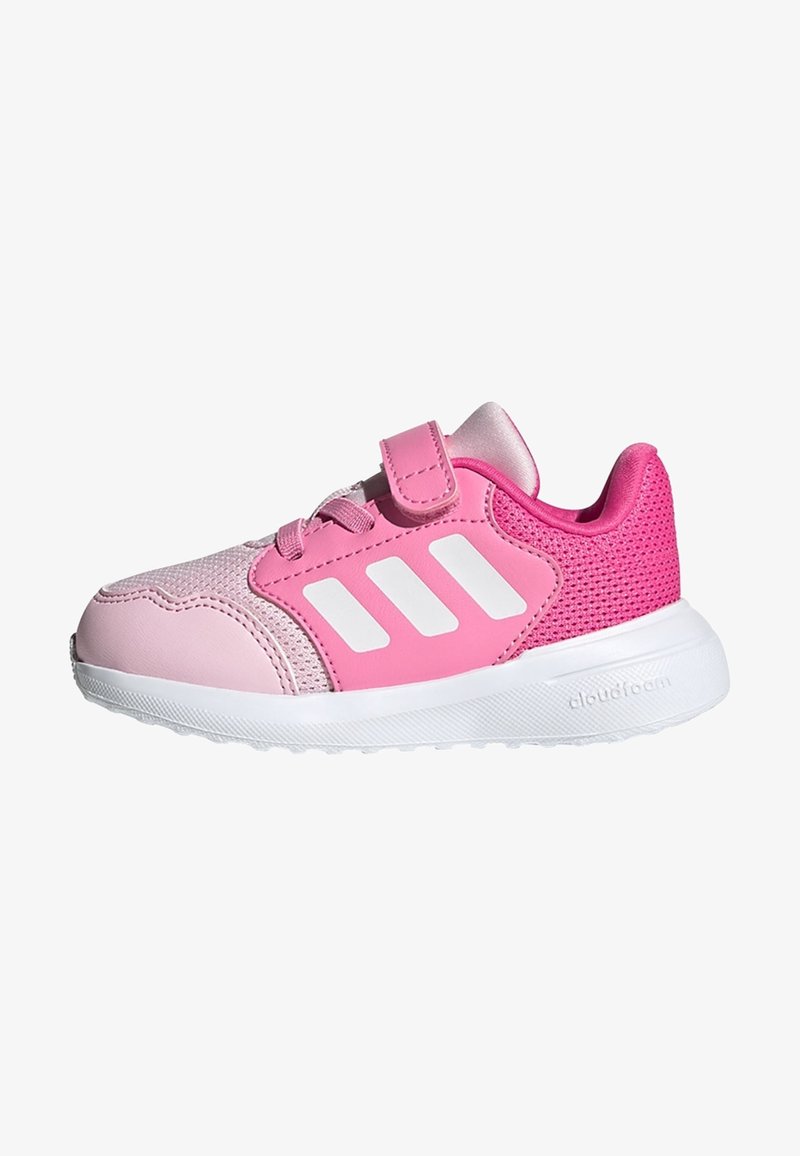 Zapatilla deportiva rosa con parte superior de malla, detalles sintéticos y logo de tres bandas en blanco. Cuenta con una tira de velcro y suela exterior blanca texturizada.
