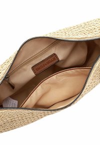Sac à pochette en paille tressée beige avec un intérieur en tissu beige lisse, une fermeture éclair et une étiquette en cuir marron avec un texte en relief.