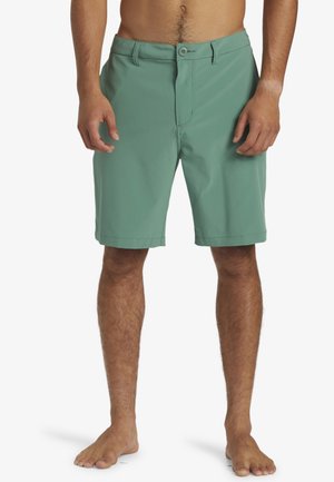 Green fabric shorts with a flat front, button closure, and side pockets. Smooth texture and knee-length design.