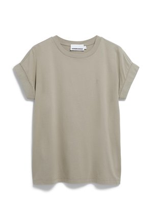 T-shirt à manches courtes et col rond en coton beige clair. Il présente des manches roulées et un petit logo en accent sur le côté gauche à l'avant.