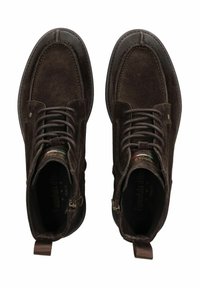 Botas de tobillo de ante marrón con un acabado texturizado, puntera redonda, suela de goma negra y cordones en la parte delantera con cremallera lateral para facilitar su uso.