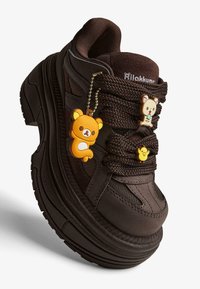 Hrubé tmavohnedé tenisky s pletenými šnúrkami ozdobené tromi charizmami postavy Rilakkuma.