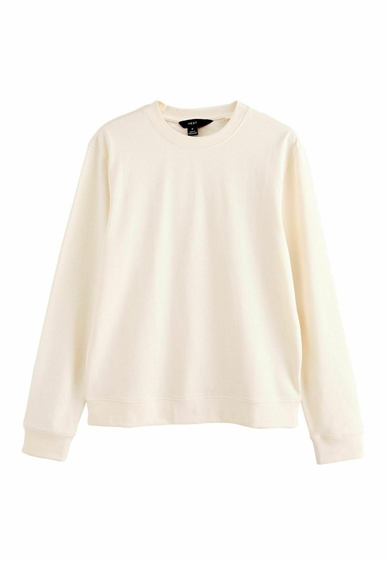 Sudadera color crema hecha de una tela suave, con cuello redondo, mangas largas, puños de canalé y un corte relajado.