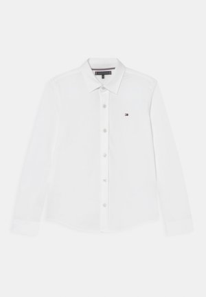 Hvid langærmet skjorte med knapper, krave, lille Tommy Hilfiger-logo på venstre bryst og mærket label inde i kraven.