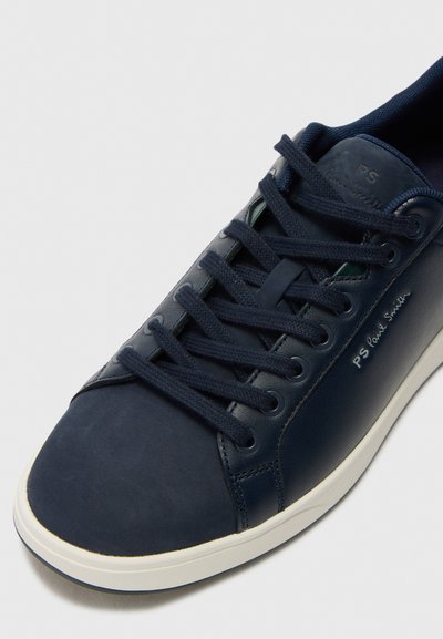 Marinblå lädersneaker med texturerad ovandel, rund tå, förstärkt sömnad, platta snören och kontrasterande vit gummisula.