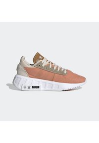 Sneakers with a pink fabric upper and beige accents, featuring a white cushioned sole, gray laces, and a logo on the heel.